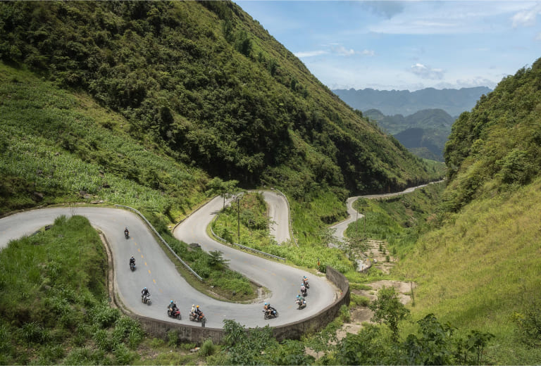 Mai Chau from Hanoi 2026 | Travel Guide, Transfer & Things To Do Ha Giang Loop mountain road in northern Vietnam with dramatic limestone karst cliffs and winding road through mountain pass