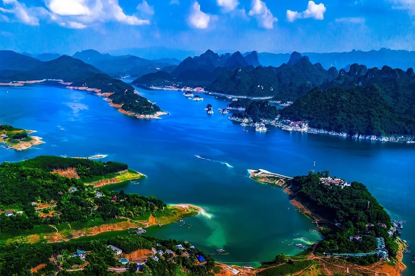 Mai Chau from Hanoi 2026 | Travel Guide, Transfer & Things To Do Hoa Binh Lake boat tour on calm water surrounded by forested karst limestone mountains near Mai Chau Vietnam