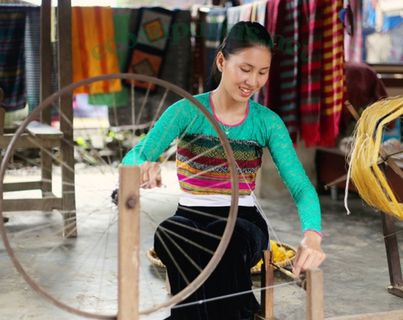 Mai Chau from Hanoi 2026 | Travel Guide, Transfer & Things To Do White Thai woman demonstrating traditional floor loom weaving technique at a cultural workshop in Lac Village Mai Chau Vietnam
