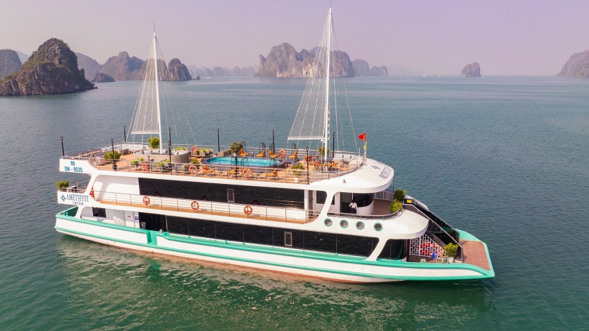 SaPa Best Things To Do Traditional junk boat cruising through Ha Long Bay limestone karsts
