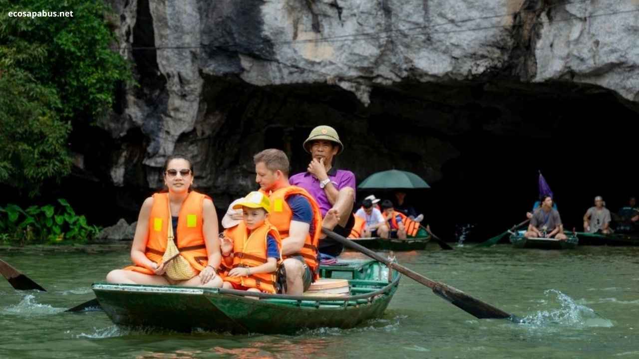 Tam Coc boat tour Ninh Binh Vietnam — wooden rowboat limestone cave karst mountain river