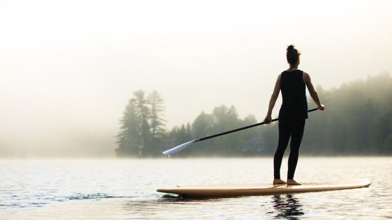 Glide Across Calm Waters On A Stand Up Paddleboard Surrounded By Nature’s Stillness